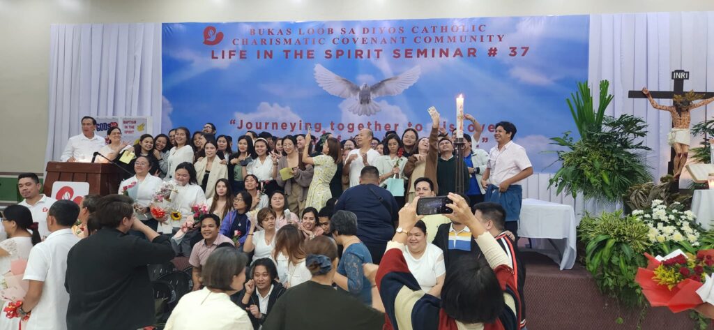 A group photo of people participating in the seminar with a poster of the seminar as a backdrop